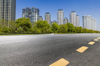 Panoramik siluet ve boş yolu, boş beton zemini olan modern iş binaları.