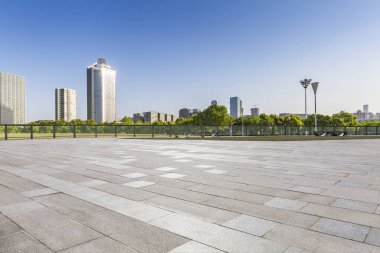 Panoramik siluet ve boş yolu, boş beton zemini olan modern iş binaları.