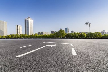 Panoramik siluet ve boş yolu, boş beton zemini olan modern iş binaları.