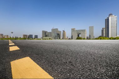 Panoramik siluet ve boş yolu, boş beton zemini olan modern iş binaları.