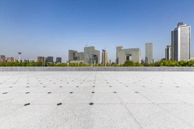 Panoramik siluet ve boş yolu, boş beton zemini olan modern iş binaları.
