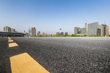 Panoramik siluet ve boş yolu, boş beton zemini olan modern iş binaları.