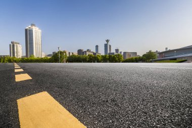 Panoramik siluet ve boş yolu, boş beton zemini olan modern iş binaları.