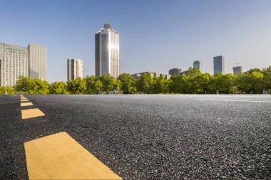 Panoramik siluet ve boş yolu, boş beton zemini olan modern iş binaları.
