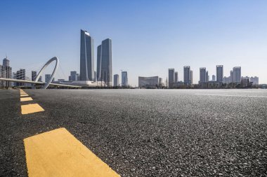 Panoramik siluet ve boş yolu, boş beton zemini olan modern iş binaları.