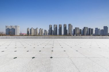 Panoramik siluet ve boş yolu, boş beton zemini olan modern iş binaları.