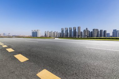 Panoramik siluet ve boş yolu, boş beton zemini olan modern iş binaları.