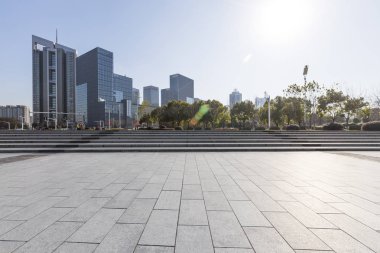 Panoramik siluet ve boş yolu, boş beton zemini olan modern iş binaları.