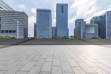 Panoramik siluet ve boş yolu, boş beton zemini olan modern iş binaları.