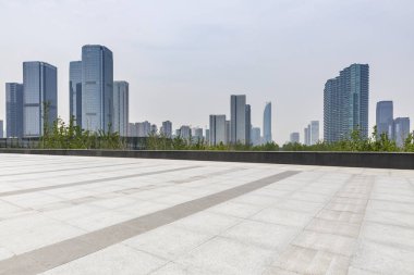 Panoramik siluet ve boş yolu, boş beton zemini olan modern iş binaları.