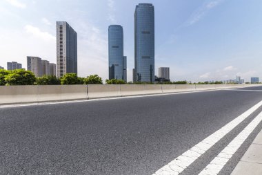 Panoramik siluet ve boş yolu, boş beton zemini olan modern iş binaları.