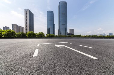 Panoramik siluet ve boş yolu, boş beton zemini olan modern iş binaları.