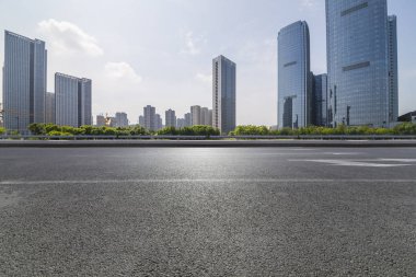Panoramik siluet ve boş yolu, boş beton zemini olan modern iş binaları.