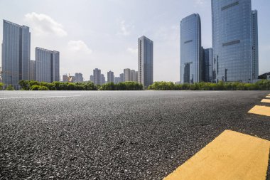 Panoramik siluet ve boş yolu, boş beton zemini olan modern iş binaları.