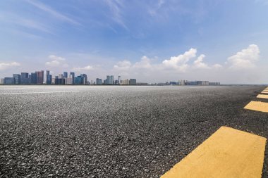 Panoramik siluet ve boş yolu, boş beton zemini olan modern iş binaları.