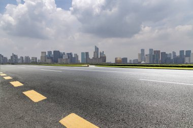 Panoramik siluet ve boş yolu, boş beton zemini olan modern iş binaları.