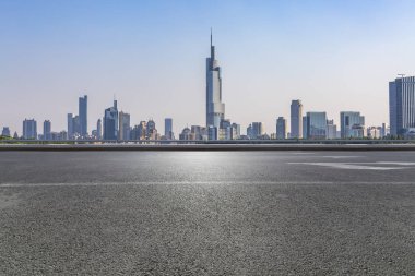 Panoramik siluet ve boş yolu, boş beton zemini olan modern iş binaları.