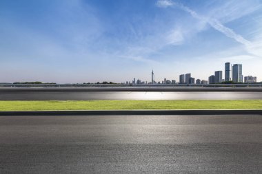 Panoramik siluet ve boş yolu, boş beton zemini olan modern iş binaları.