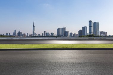 Panoramik siluet ve boş yolu, boş beton zemini olan modern iş binaları.