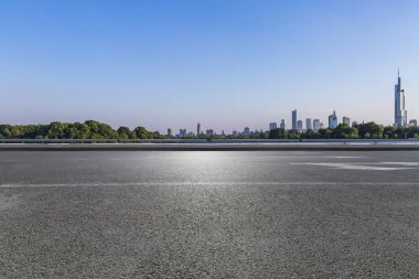 Panoramik siluet ve boş yolu, boş beton zemini olan modern iş binaları.