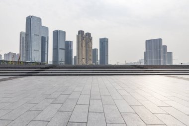 Panoramik siluet ve boş yolu, boş beton zemini olan modern iş binaları.