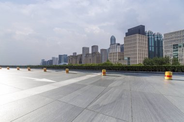 Panoramik siluet ve boş yolu, boş beton zemini olan modern iş binaları.