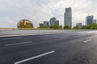 Panoramik siluet ve boş yolu, boş beton zemini olan modern iş binaları.