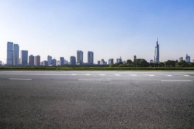 Panoramik siluet ve boş yolu, boş beton zemini olan modern iş binaları.