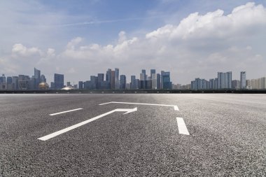 Panoramik siluet ve boş yolu, boş beton zemini olan modern iş binaları.
