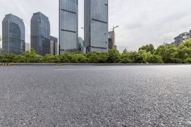 Panoramik siluet ve boş yolu, boş beton zemini olan modern iş binaları.