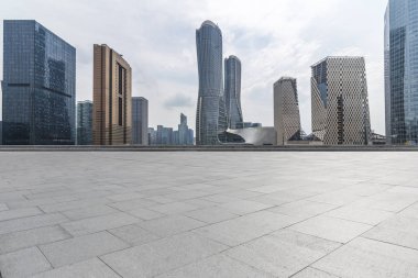 Panoramik siluet ve boş yolu, boş beton zemini olan modern iş binaları.