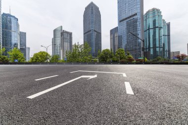 Panoramik siluet ve boş yolu, boş beton zemini olan modern iş binaları.