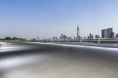 Panoramik siluet ve boş yolu, boş beton zemini olan modern iş binaları.