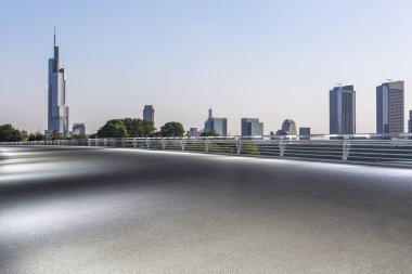 Panoramik siluet ve boş yolu, boş beton zemini olan modern iş binaları.