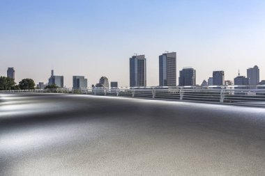 Panoramik siluet ve boş yolu, boş beton zemini olan modern iş binaları.