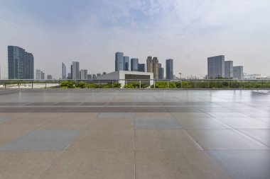 Panoramik siluet ve boş yolu, boş beton zemini olan modern iş binaları.