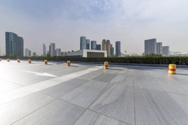 Panoramik siluet ve boş yolu, boş beton zemini olan modern iş binaları.