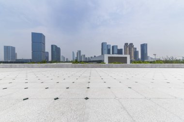 Panoramik siluet ve boş yolu, boş beton zemini olan modern iş binaları.