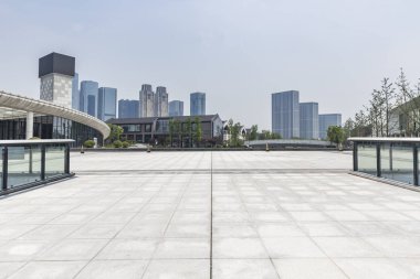 Panoramik siluet ve boş yolu, boş beton zemini olan modern iş binaları.