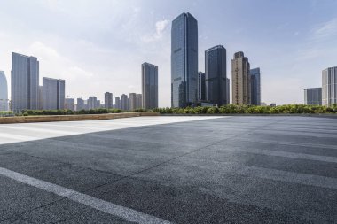 Panoramik siluet ve boş yolu, boş beton zemini olan modern iş binaları.