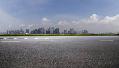 Panoramik siluet ve boş yolu, boş beton zemini olan modern iş binaları.