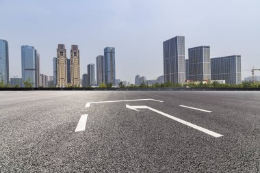 Panoramik siluet ve boş yolu, boş beton zemini olan modern iş binaları.