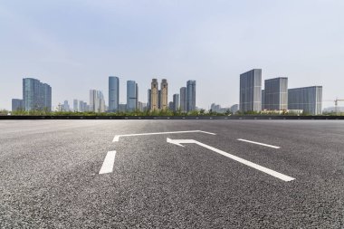 Panoramik siluet ve boş yolu, boş beton zemini olan modern iş binaları.