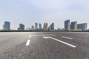 Panoramik siluet ve boş yolu, boş beton zemini olan modern iş binaları.