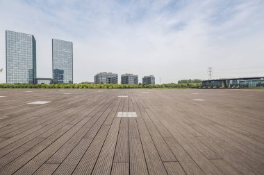 Panoramik siluet ve boş yolu, boş beton zemini olan modern iş binaları.