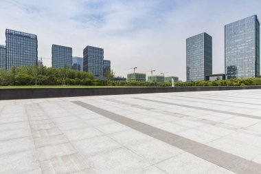 Panoramik siluet ve boş yolu, boş beton zemini olan modern iş binaları.