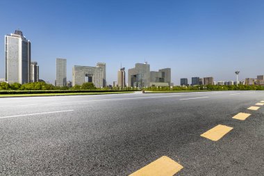Panoramik siluet ve boş yolu, boş beton zemini olan modern iş binaları.