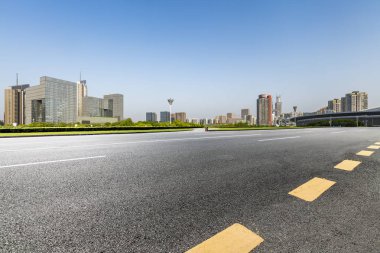 Panoramik siluet ve boş yolu, boş beton zemini olan modern iş binaları.