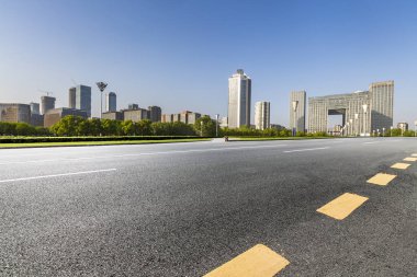 Panoramik siluet ve boş yolu, boş beton zemini olan modern iş binaları.