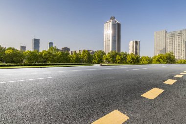 Panoramik siluet ve boş yolu, boş beton zemini olan modern iş binaları.